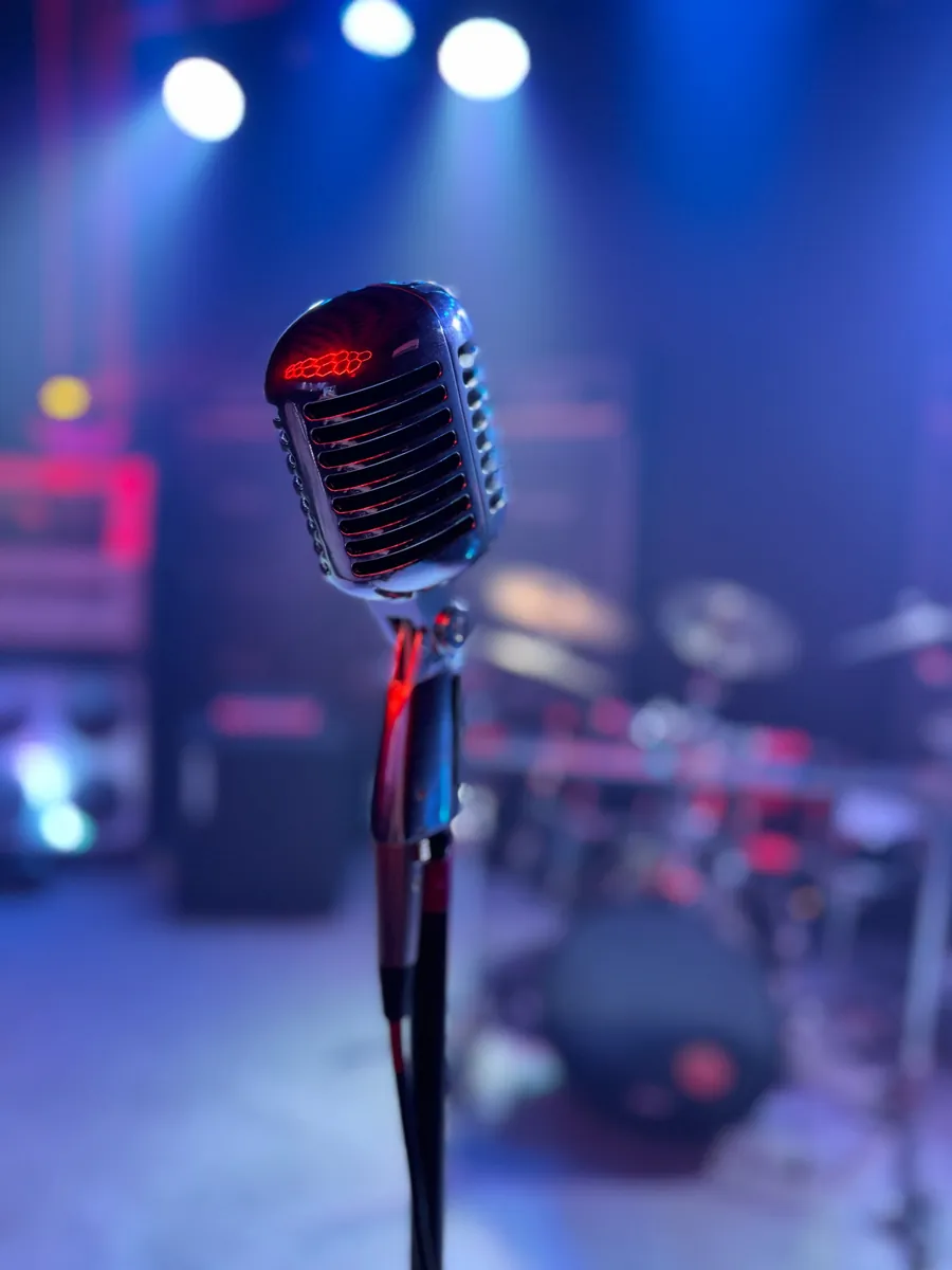 Vintage-style microphone on the VIP Studios stage with stage lights behind